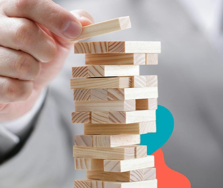Stacking jenga pieces to represent stepping blocks of building a business plan